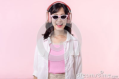 happy young asian woman model with stylish trendy sun glasses enjoy listening music by headphone audio and dancing isolated on Stock Photo