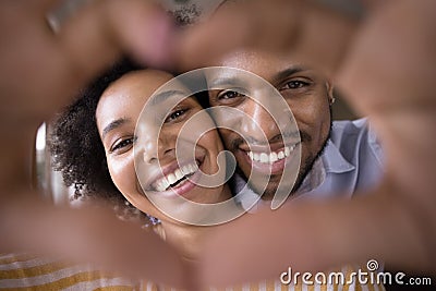 Happy young Black couple faces in finger heart shaped frame Stock Photo