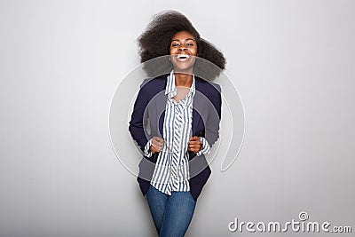 Happy young black woman with blazer against gray background Stock Photo