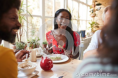 Happy young black woman eating brunch with friends at a cafe Stock Photo