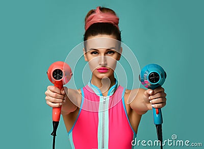 Happy young brunette woman with hair dryer on blue mint background Stock Photo