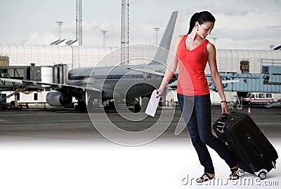 Woman walking in airport ready to board an airplan Stock Photo
