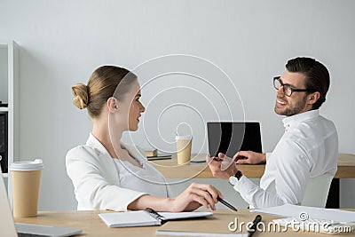 happy young business colleagues chatting at workplace Stock Photo