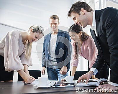 Happy young business people brainstorming at conference table Stock Photo