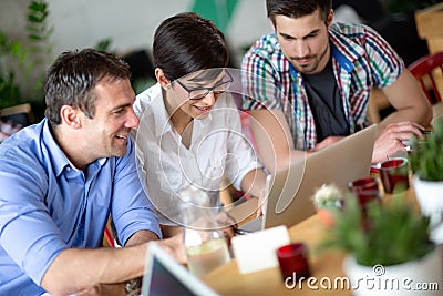 Happy young business people working in coffee shop Stock Photo