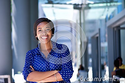 Happy young business woman standing outside office building Stock Photo