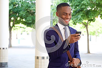 Happy young businessman reading text message on his mobile phone Stock Photo