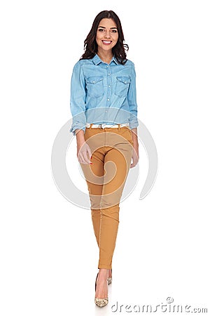 Happy young casual woman walking forward and smiles Stock Photo