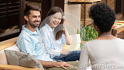 Happy young caucasian couple planning wedding listening to african planner Stock Photo