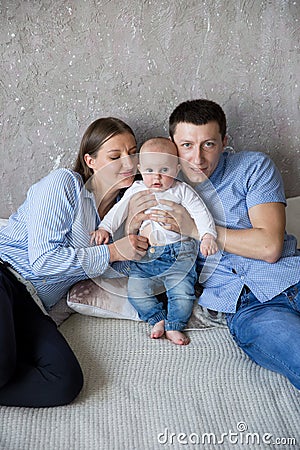 Happy Young Caucasian Family Lying on Bed Stock Photo