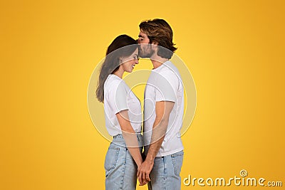 Happy young caucasian man kiss at forehead woman in white t-shirt, enjoy date Stock Photo