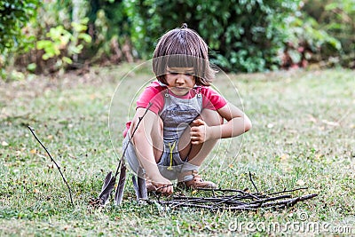 Happy young child learning to build with twigs and feathers Stock Photo