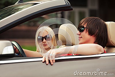 Happy young couple driving convertible car Stock Photo