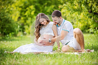 Happy young couple expecting baby, pregnant woman with husband touching belly Stock Photo