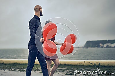 Happy young couple guy and girl are walking in the rain with bubble balls. hello concept autumn, good mood Stock Photo