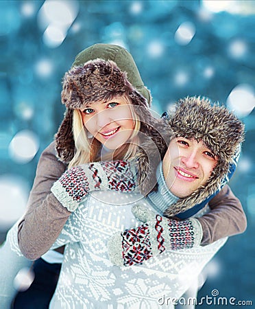 Happy young couple having fun playing outdoors in winter Stock Photo