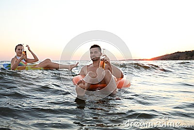 Happy young couple on inflatable rings Stock Photo