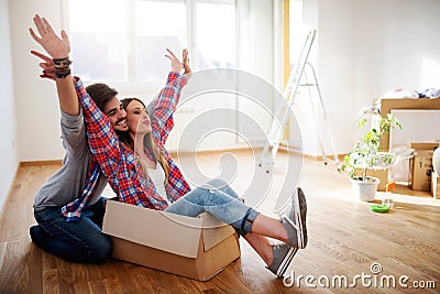 Happy young couple just moved new home unpacking boxes; having fun Stock Photo