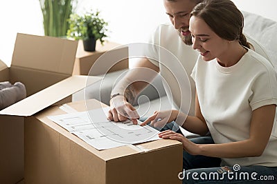 Happy young couple looking at blueprint planning new home design Stock Photo