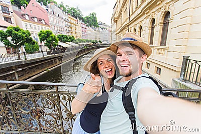 Happy young couple in love takes selfie portrait in Karlovy Vary in Czech Republic. Pretty tourists make funny photos Stock Photo