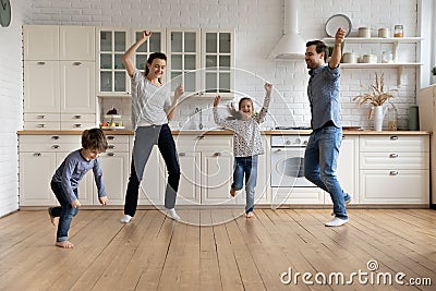 Happy young couple parents dancing with small kids. Stock Photo