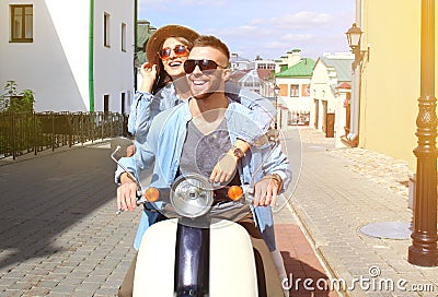 Happy young couple riding scooter in town. Handsome guy and young woman travel. Adventure and vacations concept. Stock Photo