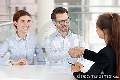 Happy young couple signing mortgage insurance investment contract handshake broker Stock Photo