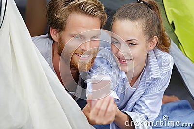 Happy young couple in tent during camping Stock Photo