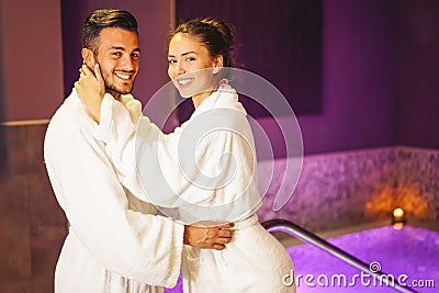 Happy young couple wearing bathrobe enjoying the spa day during their honeymoon - Romantic lovers having relax in a hotel spa Stock Photo