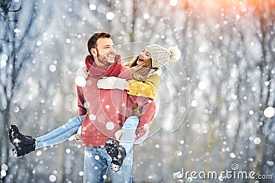 Happy Young Couple in Winter Park laughing and having fun. Family Outdoors. Stock Photo