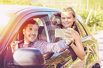 Happy young couples on road trip taking selfie while driving on countryside road Stock Photo