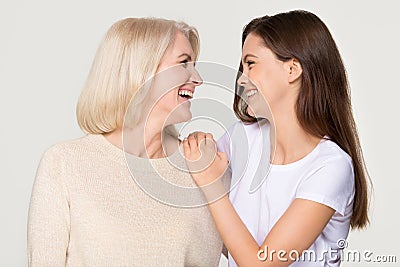 Happy young daughter embracing mature mother laughing isolated on background Stock Photo