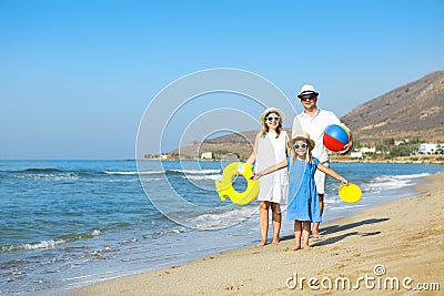 Happy young family having fun running on beach at sunset. Family Stock Photo