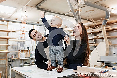 Happy young family with the little son in the carpenter workshop Stock Photo