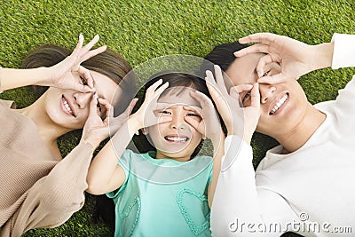 Happy Young Family lying on the grass Stock Photo