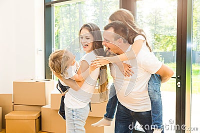 Happy young family, parents daughter and son, unpacking boxes and moving into a new home. funny kids run in with boxes Stock Photo