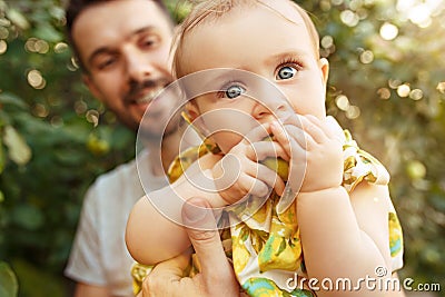 The happy young family during picking apples in a garden outdoors Stock Photo