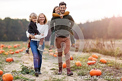 Happy young family in pumpkin patch field Stock Photo