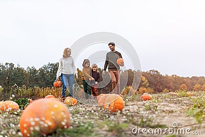 Happy young family in pumpkin patch field Stock Photo