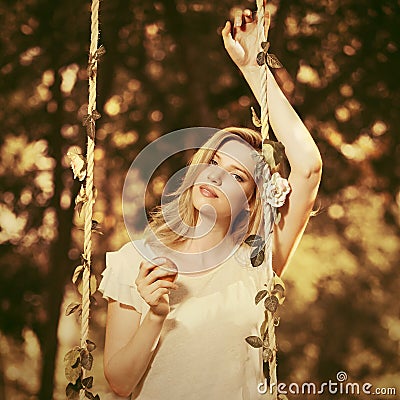 Happy young fashion blond woman with apple in city park Stock Photo