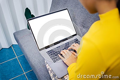 Happy young female surfing the internet shopping online at home after the government announced a ban on leaving the house., Stock Photo