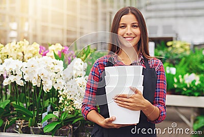 Happy young florist working in a hothouse Stock Photo