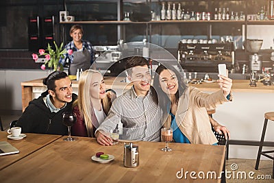 Happy young friends drinking coffee at cafe Stock Photo