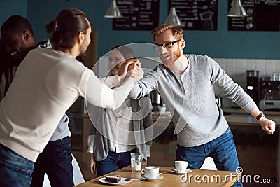 Happy young friends greeting at friendly meeting in cafe Stock Photo