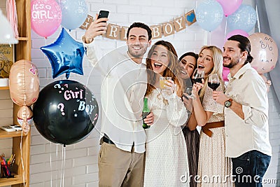 Happy young friends taking selfie together during gender reveal party Stock Photo