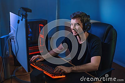 Happy young gamer playing video game at home Stock Photo