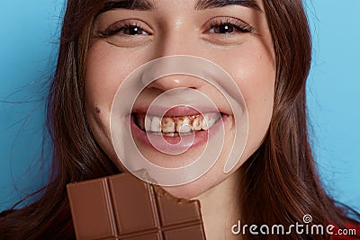 Happy young girl with chocolate on her teeth looking directly at camera and laughing likes eating sweets face of joyful lady Stock Photo