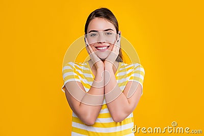happy young girl touch face in summer striped tshirt on yellow background Stock Photo