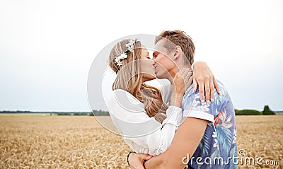 Happy young hippie couple kissing in field Stock Photo