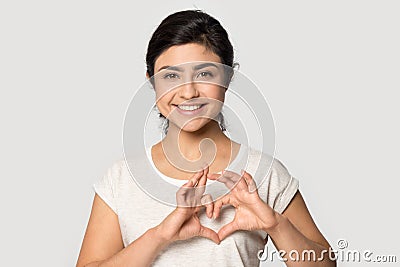 Happy young indian ethnicity woman making heart shape gesture symbol. Stock Photo